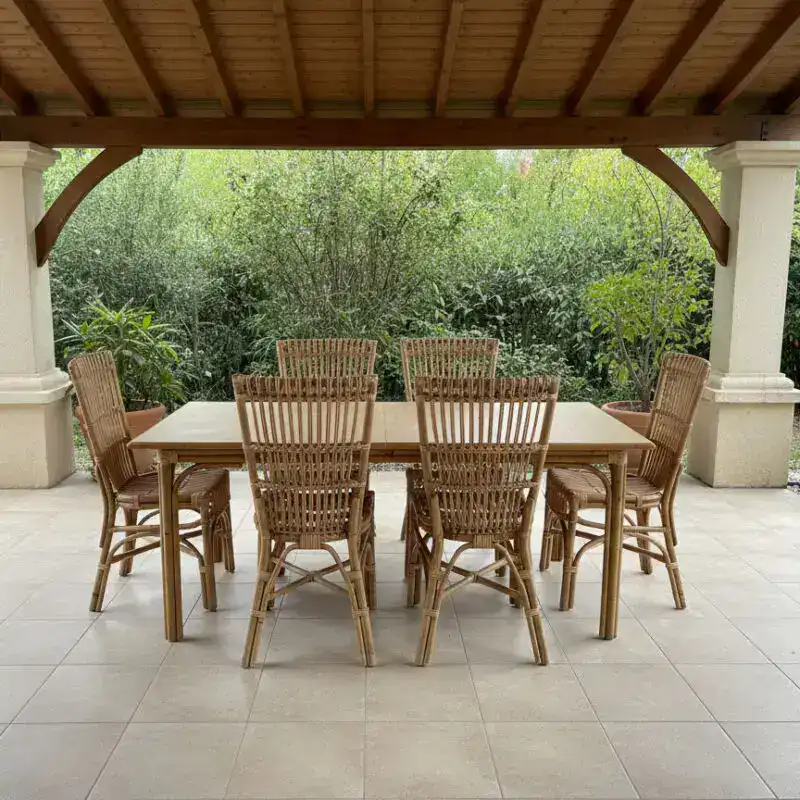 Tavolo da esterno in rattan con sedie in giardino, arredo elegante e resistente.