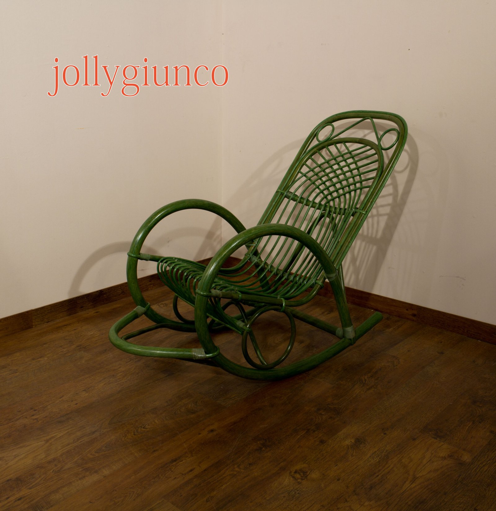 jollygiuncopoltrone6g jollygiuncoeu green wicker chair leaning diagonally in a corner of a room with a wooden floor and beige walls