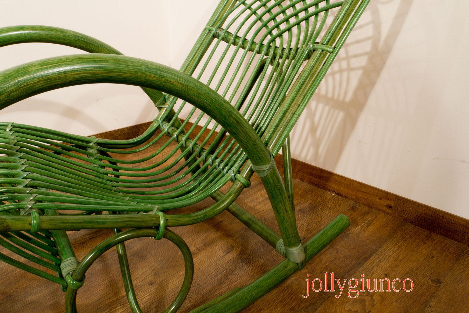 jollygiuncopoltrone7g jollygiuncoeu green woven wicker chairs tangled together on a wooden floor with red text jollygiunco at the bottom edge