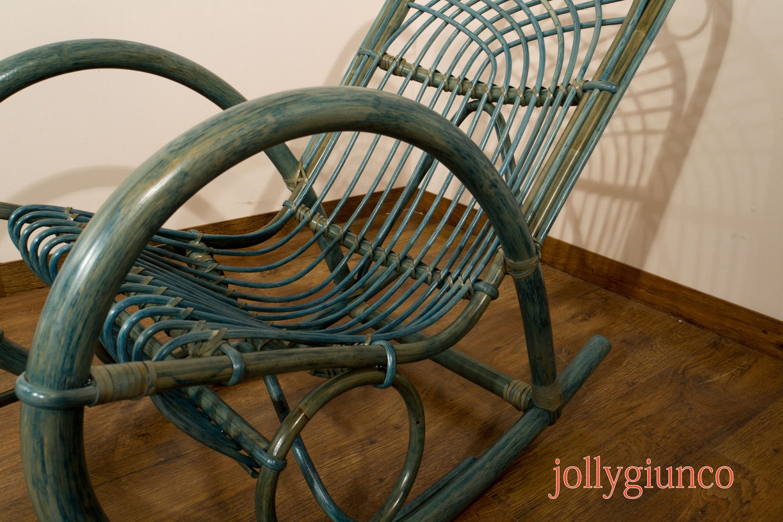jollygiuncopoltrone9g jollygiuncoeu close up of blue green woven wicker chair frames overlapping on a wooden floor