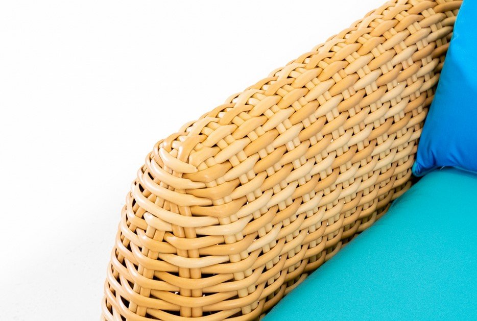 Bombo Divano 3 posti77 jollygiuncoeu close up of woven rattan chair with a turquoise cushion and blue pillow