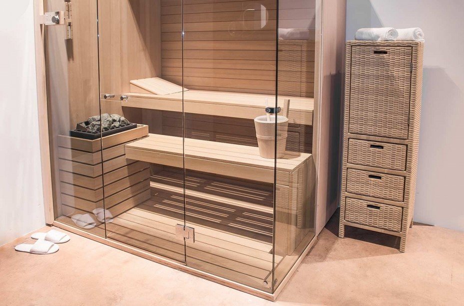 Cabinet modulo 1 anta 3 cassetti Polyrattan3 jollygiuncoeu glass enclosed wooden sauna with two benches heated stones on a small heater and a woven drawer unit to the right slippers near the door