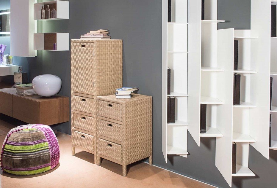 Cabinet modulo 3 cassetti Polyrattan5 jollygiuncoeu modern showroom scene with a woven wicker storage cabinet and matching drawers against a gray wall beige floor