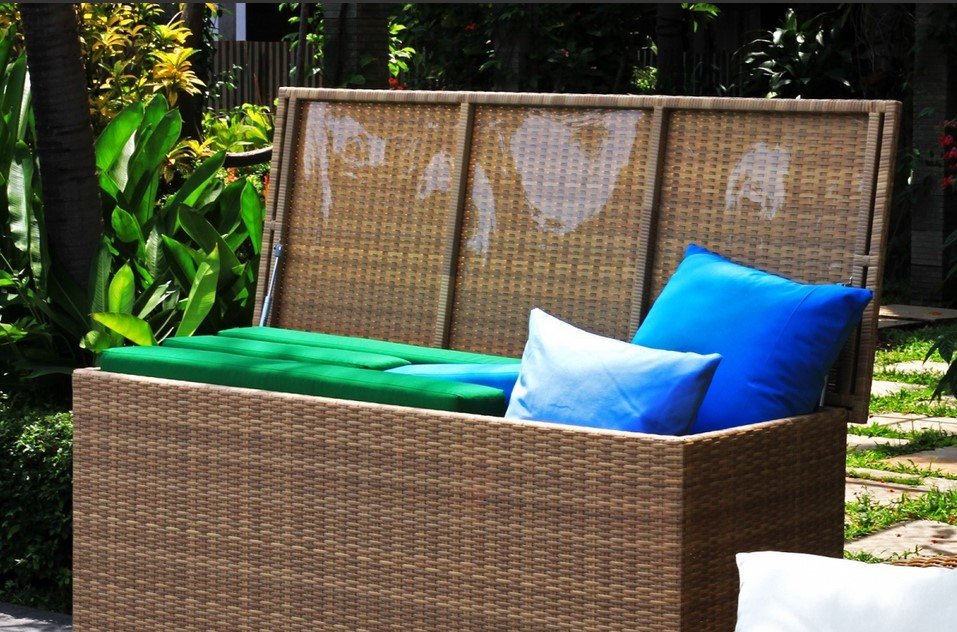 Cushion box baule Polyrattan3 jollygiuncoeu wicker outdoor storage bench with green cushions and blue pillows in a garden setting lid open behind it