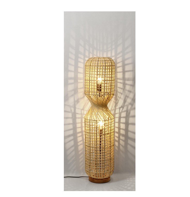 PIANTANA MALABO BEIGE H1042 jollygiuncoeu tall floor lamp made of woven rattan with two stacked lantern like sections lit and casting geometric shadows on the wall