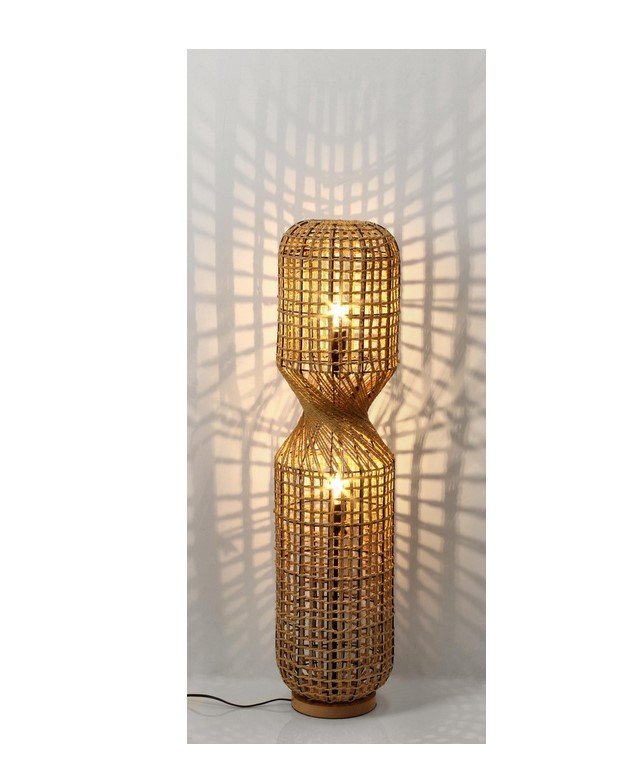 PIANTANA MALABO NATURALE H1042 jollygiuncoeu tall wicker floor lamp with two glowing bulbs casting geometric lattice shadows on the wall behind it