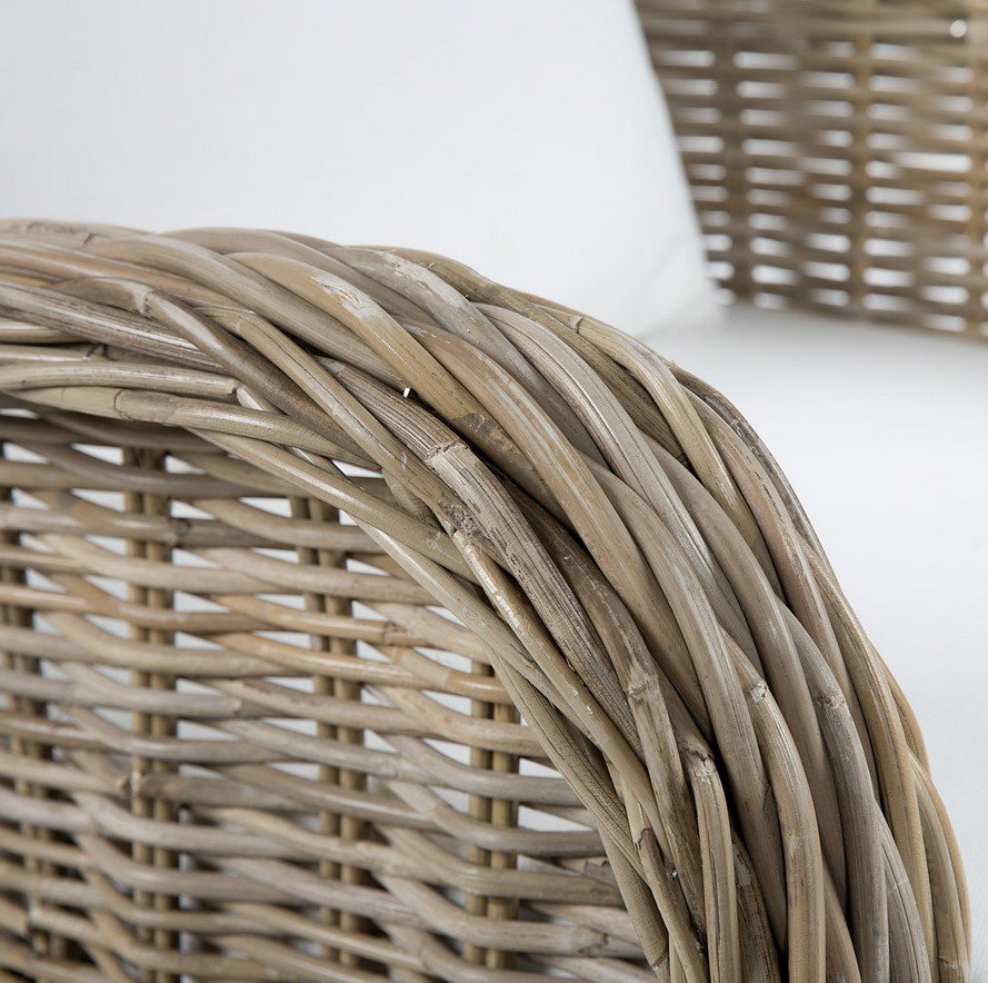 Poltrona Katrina in Kubu Grey1 jollygiuncoeu close up of a woven wicker basket with a curved handle and natural beige fibers