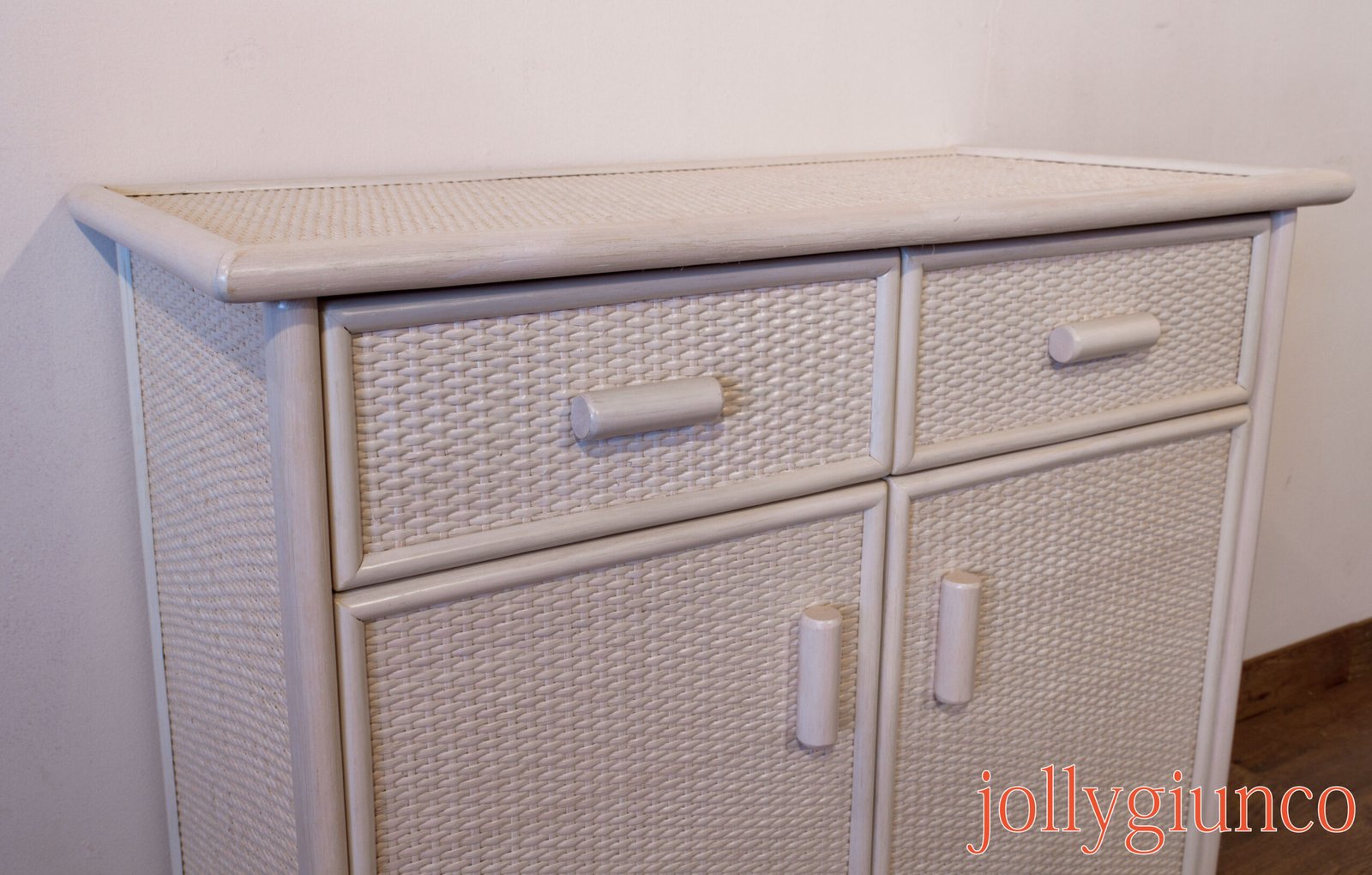 jollygiuncovari41g jollygiuncoeu white wicker chest of drawers with rounded edges against a light wall featuring woven drawer fronts and light knobs orange text in the bottom right reads jollygiunco