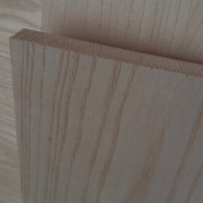 Close-up of light-colored plywood boards with visible grain and stacked edges.